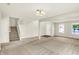 Open living area with neutral carpet, white walls, and a staircase leading to the upper level of the home at 11437 High Grass Dr, Indianapolis, IN 46235
