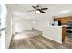 Bright living room with wood-look floors, view to a kitchen, and an adjacent bathroom at 11437 High Grass Dr, Indianapolis, IN 46235