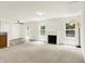Open-concept living room with fireplace, access to a backyard patio, and a view to an adjacent kitchen at 11437 High Grass Dr, Indianapolis, IN 46235