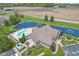 Beautiful aerial view of a pool, pond, and clubhouse amidst lush green lawns and landscaping at 1146 Distinctive Way, Greenfield, IN 46140