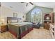 Comfortable bedroom with a large arched window, ceiling fan, and hardwood floors at 1146 Distinctive Way, Greenfield, IN 46140