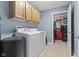 Well-lit laundry room with washer, dryer, upper cabinets and neutral-colored walls and floor at 1146 Distinctive Way, Greenfield, IN 46140
