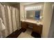 Well-lit bathroom featuring a double sink vanity, tile flooring, shower with curtain and ample counter space at 11621 Coastal Dr, Indianapolis, IN 46229