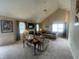 Spacious living room featuring vaulted ceilings, a fireplace, neutral carpet, and large windows at 11621 Coastal Dr, Indianapolis, IN 46229