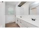 Well-lit bathroom featuring double sinks, white tile and wood-look flooring at 12112 Roxbury Pl, Carmel, IN 46033
