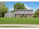 Traditional two-story home with gray siding, brick accents, manicured lawn, and mature trees at 12112 Roxbury Pl, Carmel, IN 46033