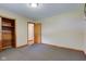 Bedroom with carpeted flooring, closet, and view into adjacent room with wood flooring at 132 S First St, Jamestown, IN 46147