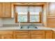 Close up on a kitchen sink with wood cabinets and a view of the backyard at 132 S First St, Jamestown, IN 46147