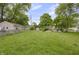 A backyard features a grassy lawn, a fence and views of neighboring homes at 1411 N Grant Ave, Indianapolis, IN 46201