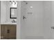 Updated bathroom with stone tile shower, modern vanity, and black and white floors at 1411 N Grant Ave, Indianapolis, IN 46201