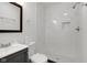 This bathroom features a vanity and a walk-in shower with marble-look tiling at 1411 N Grant Ave, Indianapolis, IN 46201