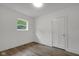 Bright bedroom featuring wood-look floors, a window and a paneled door at 1411 N Grant Ave, Indianapolis, IN 46201