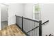Hallway with black railing and overhead lighting at 1425 N Grant Ave, Indianapolis, IN 46201