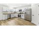 Bright kitchen featuring white cabinets, stainless steel appliances, and wood-look flooring at 1425 N Grant Ave, Indianapolis, IN 46201