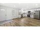 Open kitchen with white cabinets, stainless steel appliances, and wood-look flooring at 1425 N Grant Ave, Indianapolis, IN 46201