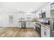 Bright kitchen featuring white cabinets, stainless steel appliances, and wood-look flooring at 1425 N Grant Ave, Indianapolis, IN 46201