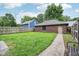 Backyard view with lush green grass, wooden fence and a detached garage at 1436 Central Ave, Indianapolis, IN 46202