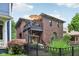 Charming brick home featuring a balcony, arched windows, and a well-manicured lawn with black fence at 1436 Central Ave, Indianapolis, IN 46202