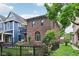 Charming brick home featuring a balcony, arched windows, and a well-manicured lawn with black fence at 1436 Central Ave, Indianapolis, IN 46202