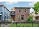 Charming brick home featuring a balcony, arched windows, and a well-manicured lawn with black fence at 1436 Central Ave, Indianapolis, IN 46202