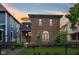 Charming brick home featuring a balcony, arched windows, and a well-manicured lawn with black fence at 1436 Central Ave, Indianapolis, IN 46202