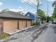 Two-car garage showing alley access and brick siding with a blue house nearby at 1436 Central Ave, Indianapolis, IN 46202