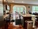 Open kitchen with dark cabinets, granite countertops, and a large island with a sink at 1518 Valdarno Dr, Greenwood, IN 46143
