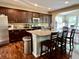 Modern kitchen with dark wood cabinets, granite countertops, and an island with bar seating at 1518 Valdarno Dr, Greenwood, IN 46143