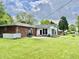 Backyard with patio, brick and white siding house and green lawn at 1579 Crest Dr, Shelbyville, IN 46176