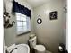 Bathroom with nautical décor, gray walls, toilet, and sink at 1579 Crest Dr, Shelbyville, IN 46176