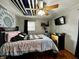 Well-lit bedroom with a plaid comforter, ceiling fan and light, and wood floors at 1579 Crest Dr, Shelbyville, IN 46176