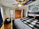 Bright bedroom with wood floors, a ceiling fan and light, and access to a bathroom at 1579 Crest Dr, Shelbyville, IN 46176