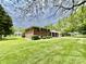 Beautiful home with a large lawn surrounded by mature trees, providing a serene and private setting at 1579 Crest Dr, Shelbyville, IN 46176