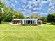 Expansive lawn view of brick home with large, sunny windows and connected sunroom at 1579 Crest Dr, Shelbyville, IN 46176