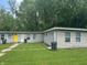 Modest exterior of a multi unit building featuring neutral siding, a bright yellow front door, and lawn at 1642 W 6Th St, Anderson, IN 46016