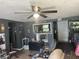 Cozy living room with ceiling fan, grey walls, and view into kitchen at 1642 W 6Th St, Anderson, IN 46016