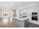 A chef's kitchen featuring a kitchen island, white cabinets, and stainless steel appliances at 1675 Solebar Way, Westfield, IN 46074