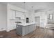 A modern kitchen with white cabinets, gray island, quartz countertops, and stainless steel appliances at 1675 Solebar Way, Westfield, IN 46074