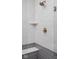Close up of walk-in shower with bronze fixtures, gray tile accent and bench at 1675 Solebar Way, Westfield, IN 46074