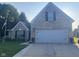 Charming brick home with a two-car garage, well-manicured lawn and patriotic American flag at 2018 Alysheba Dr, Indianapolis, IN 46234