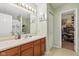Bathroom featuring a single sink vanity, large mirror, and a walk-in closet at 2114 Turning Leaf Dr, Franklin, IN 46131