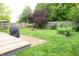 Backyard with wood deck, fire pit, fenced yard, and garden bed at 2210 Bridlewood Dr, Franklin, IN 46131