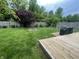 Green backyard with a fire pit, deck, and privacy fence, perfect for outdoor enjoyment at 2210 Bridlewood Dr, Franklin, IN 46131