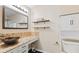 Well-lit bathroom featuring a custom sink, wood shelves, ample cabinet space, and a toilet at 2210 Bridlewood Dr, Franklin, IN 46131