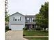 Charming two-story home with well-manicured lawn, attached garage and an inviting front porch with an American flag at 2210 Bridlewood Dr, Franklin, IN 46131