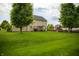 Expansive backyard with lush lawn, mature trees, and a play set, perfect for outdoor fun at , Plainfield, IN 46168