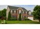 Charming two-story brick home with black shutters, manicured lawn, and attached two-car garage at , Plainfield, IN 46168