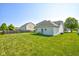 A spacious backyard with healthy green grass, a well-maintained lawn, and a home with neutral siding and roofing at 2234 Burgundy Way, Plainfield, IN 46168