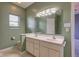 Green bathroom with a double sink vanity, a large mirror, lighting, and a small window at 2234 Burgundy Way, Plainfield, IN 46168