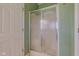 A green bathroom with a glass door shower, a white door, and tile flooring at 2234 Burgundy Way, Plainfield, IN 46168